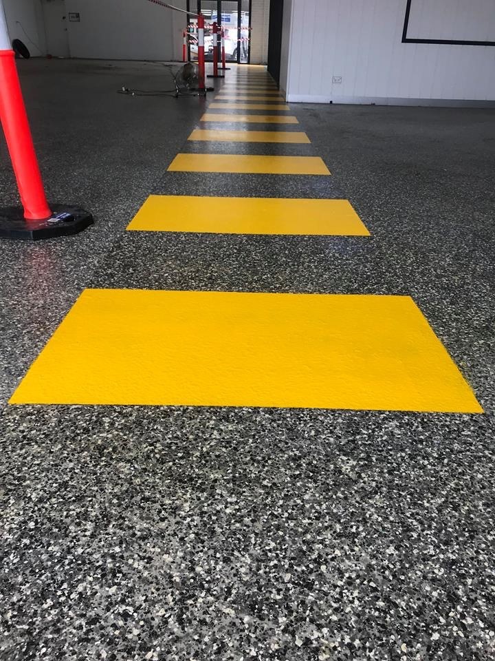 Safety yellow coating applied to previously painted industrial surface